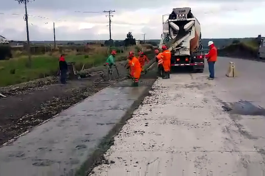 Hormigonado de la calzada de un camino rural: la cuadrilla trabajando la superficie con el mixer al fondo