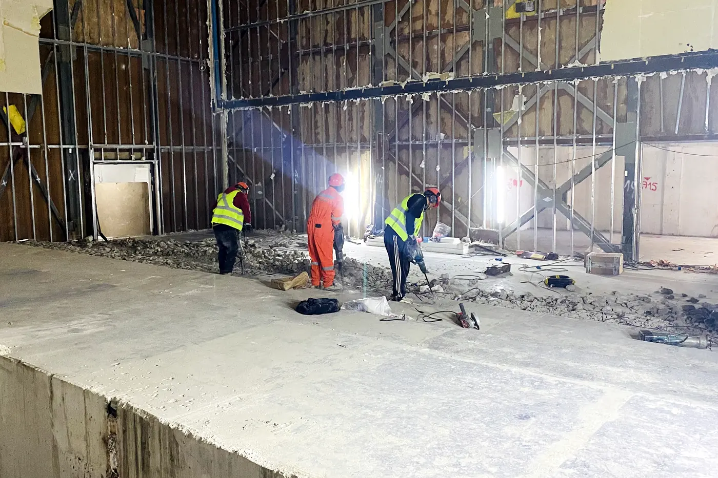 Interior de un recinto comercial en demolición, con la cuadrilla retirando escombro