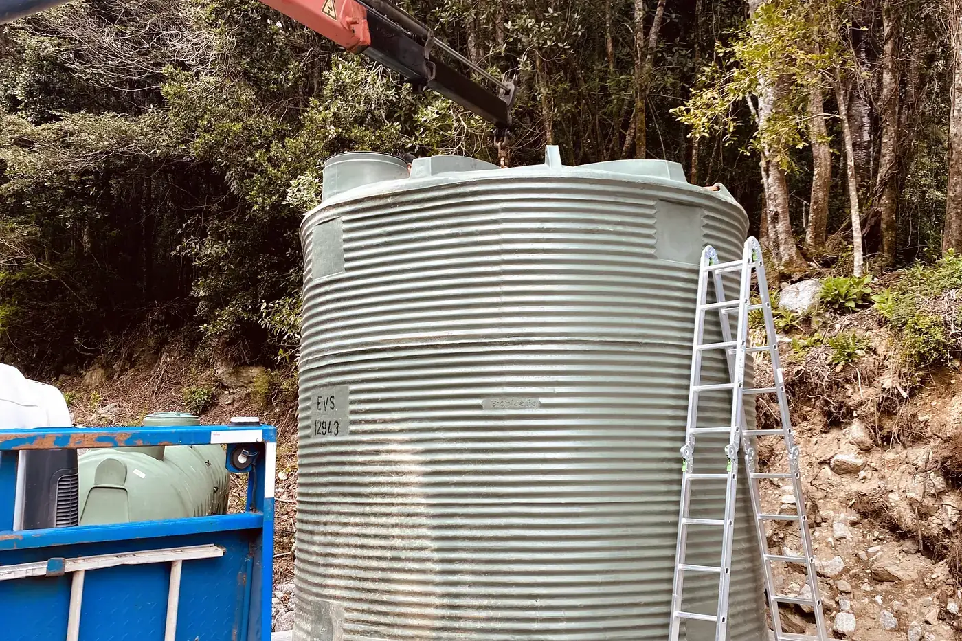 Estanque de agua ya montado sobre su radier de hormigón, con la escalera de acceso apoyada