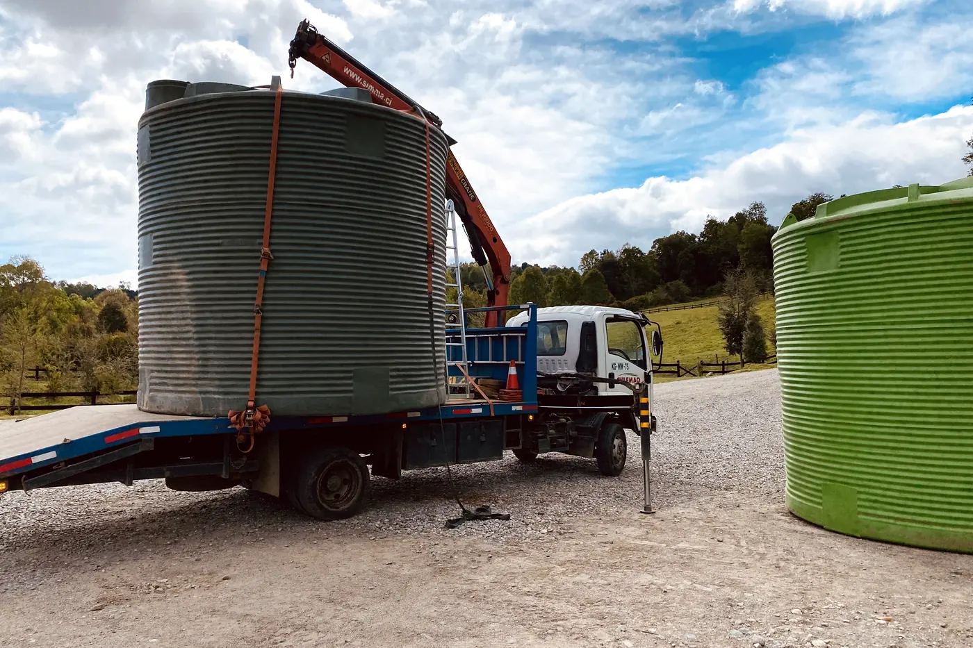 Dos estanques de agua de gran capacidad cargados en la rampa de un camión, listos para el traslado
