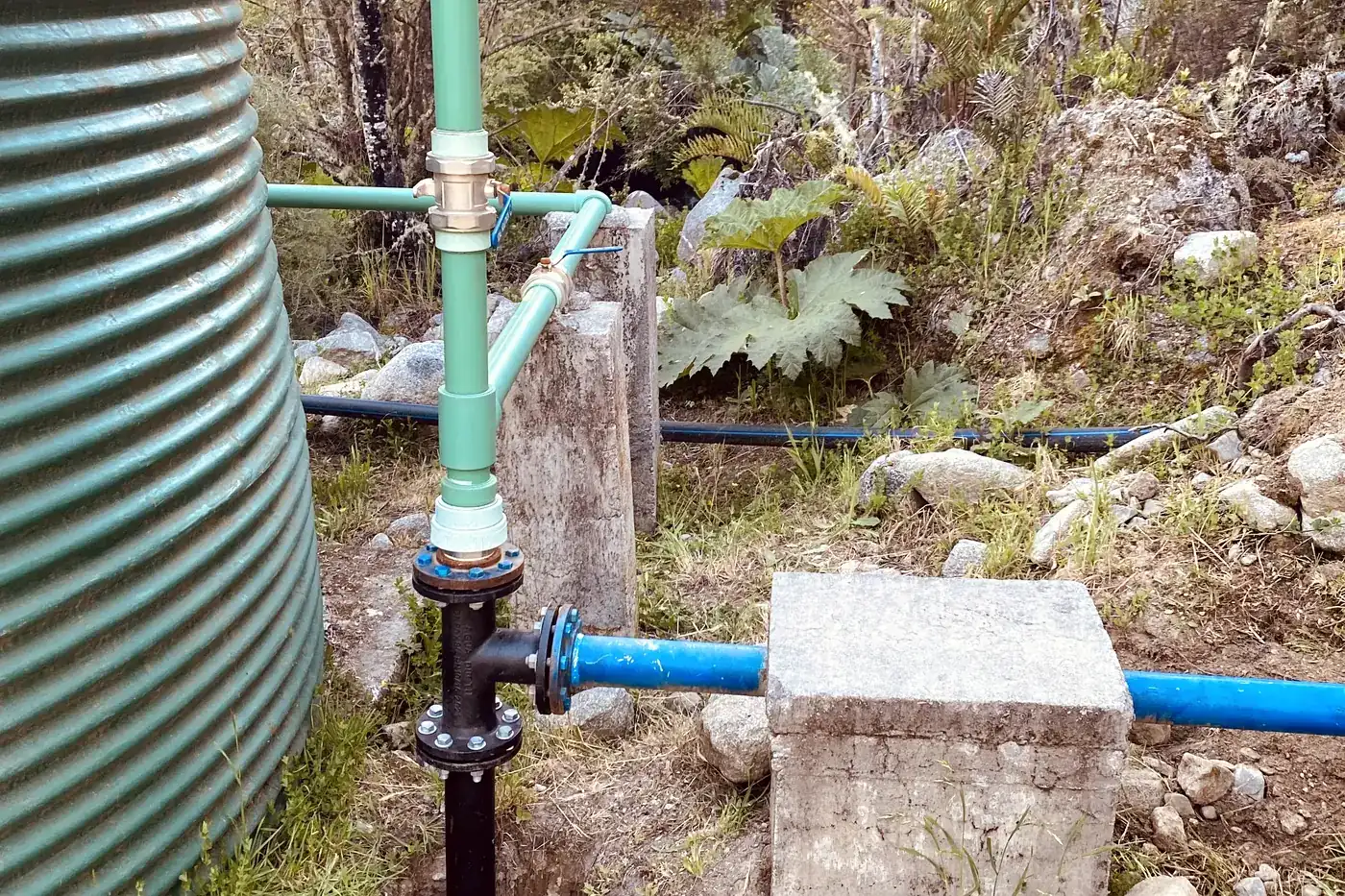 Matriz de salida terminada al pie del estanque: cañería, válvulas y machón de hormigón