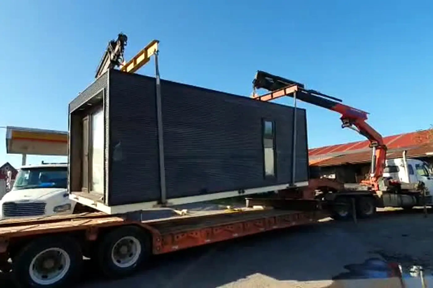 El camión grúa cargando la Tiny House sobre la rampa para el traslado