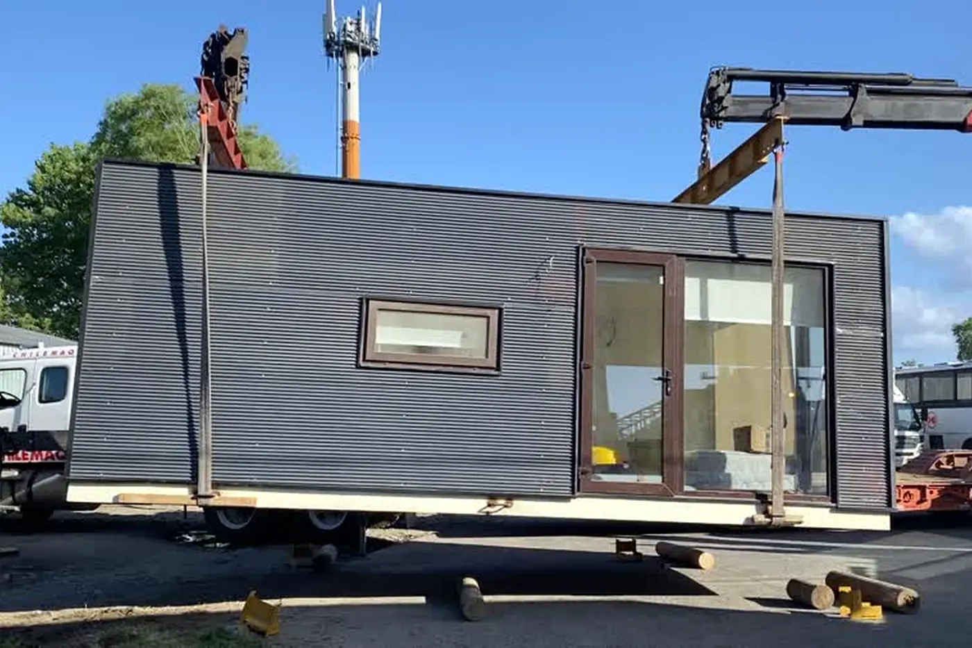 La Tiny House suspendida de la grúa, con las eslingas tomadas de su base
